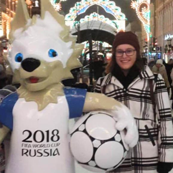 a female student poses with a wolf statue in Russia