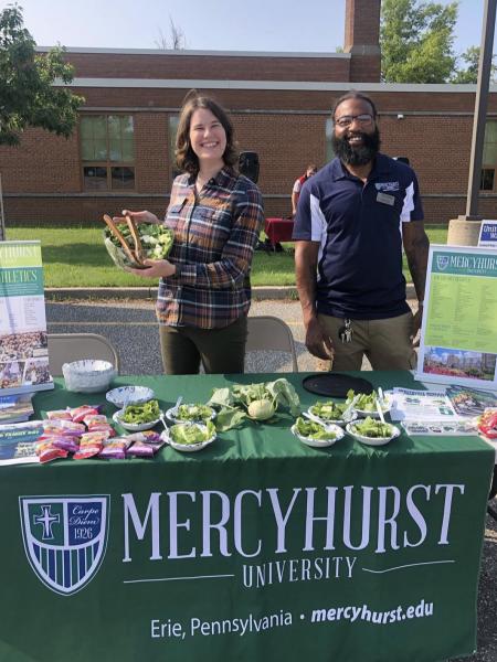 Mercyhurst staff handing out produce at a community event