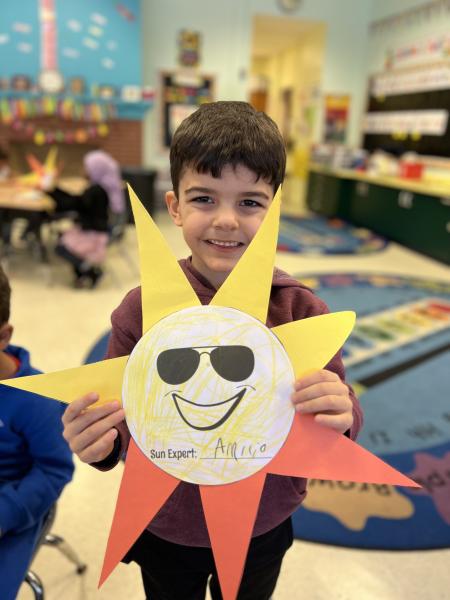 a child holds a sunshine art project 