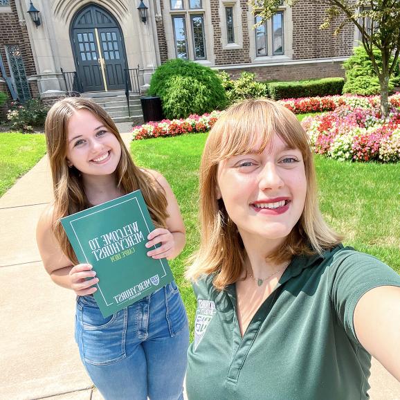 Mercyhurst University ambassador and new student, posing for a folder with Welcome folder