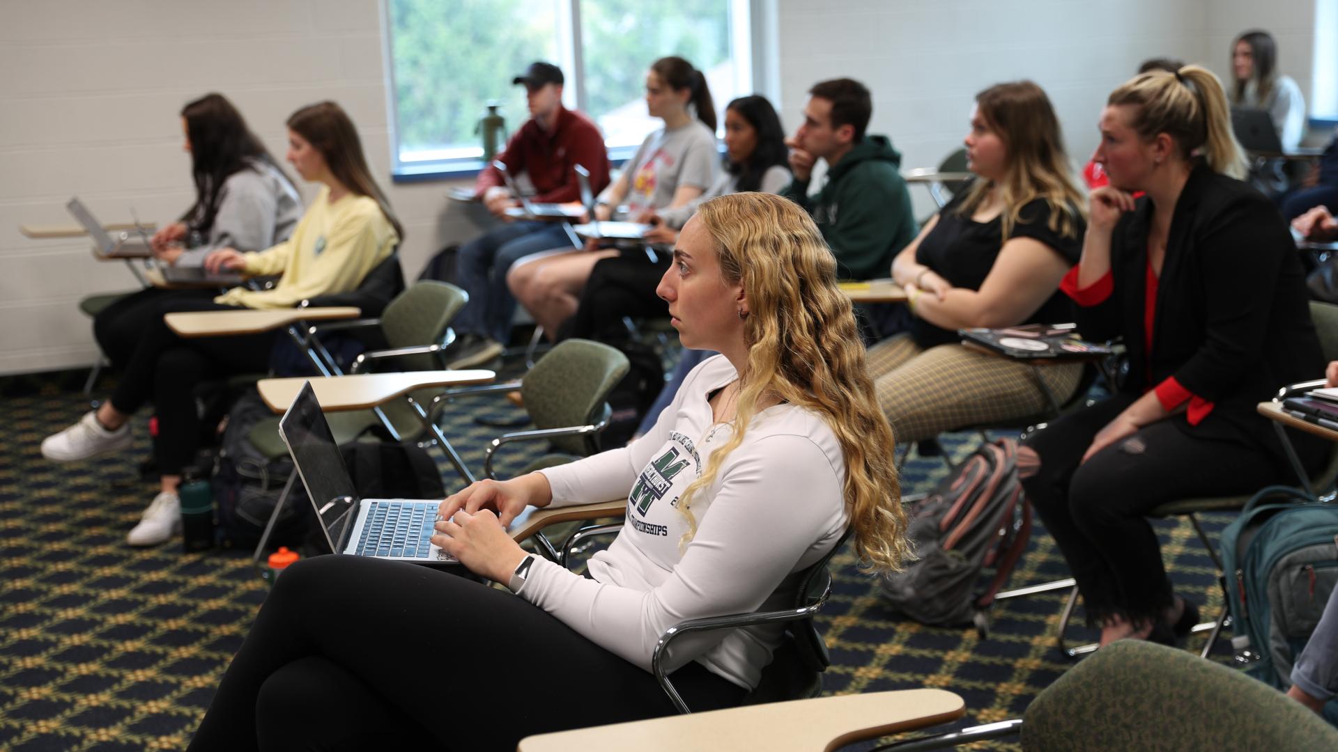 side angle of college students sitting in a classroom 