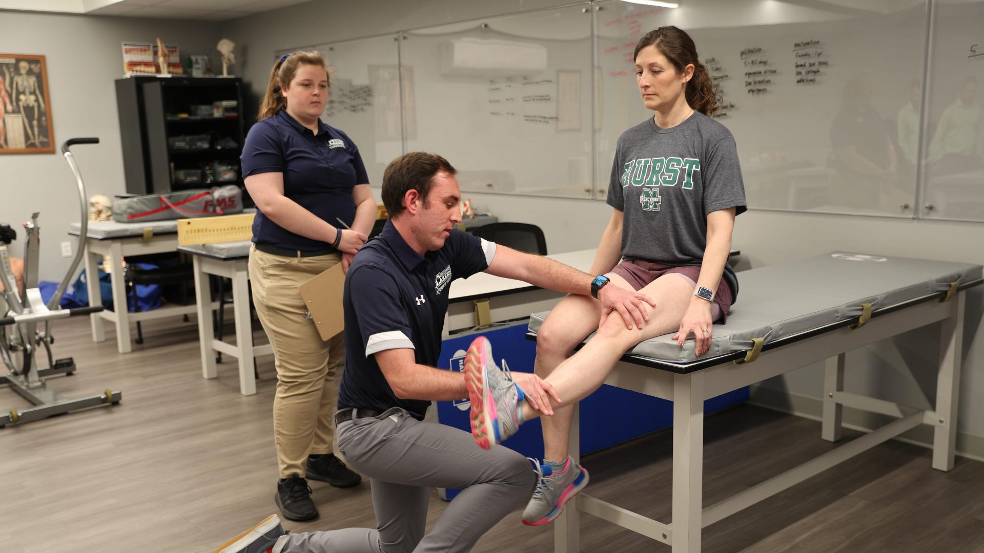 two students performing an evaluation on a patient