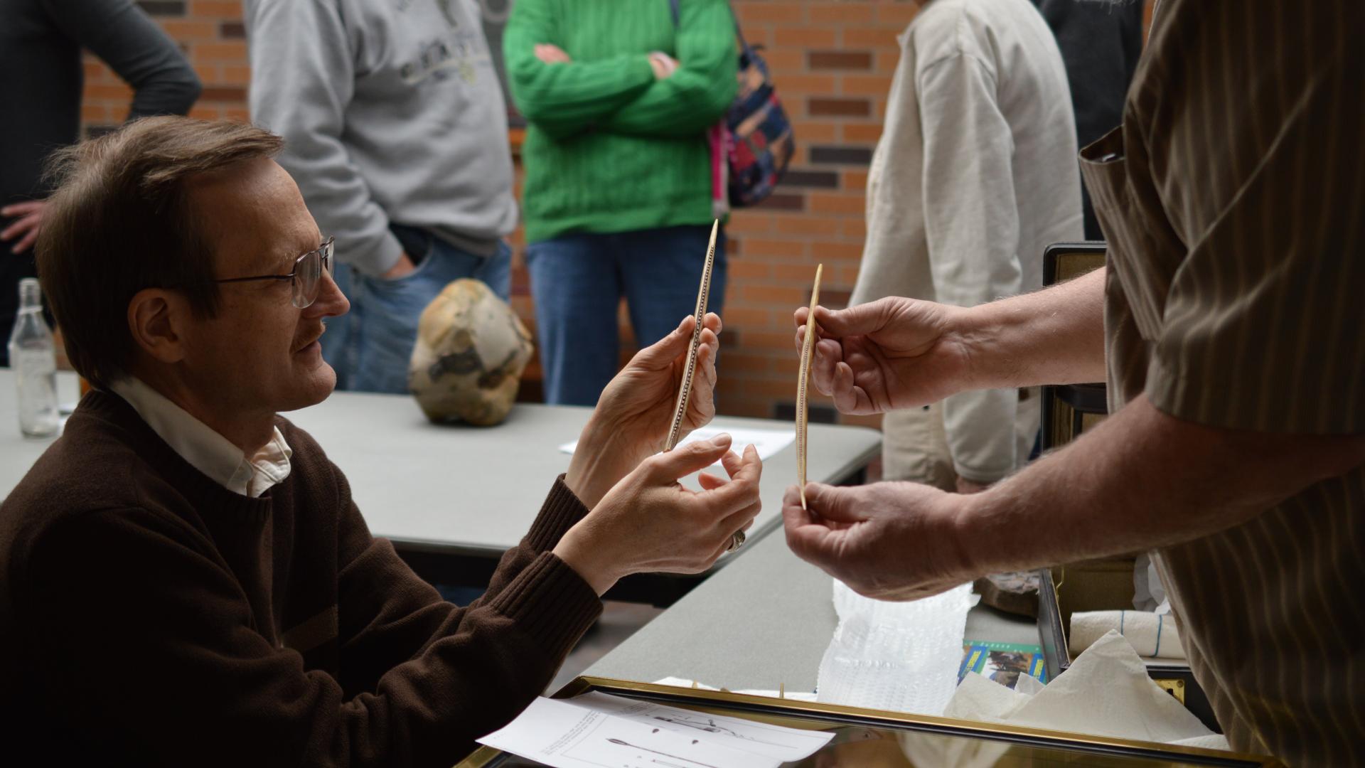 Two people examining artifacts