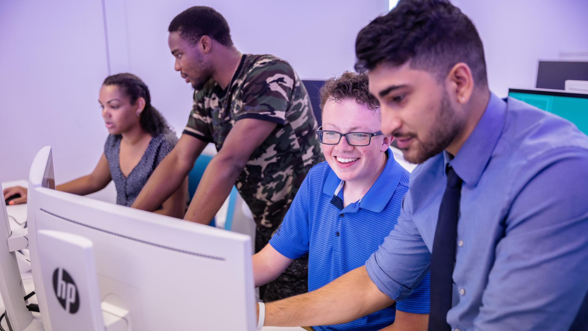 four students looking at computers