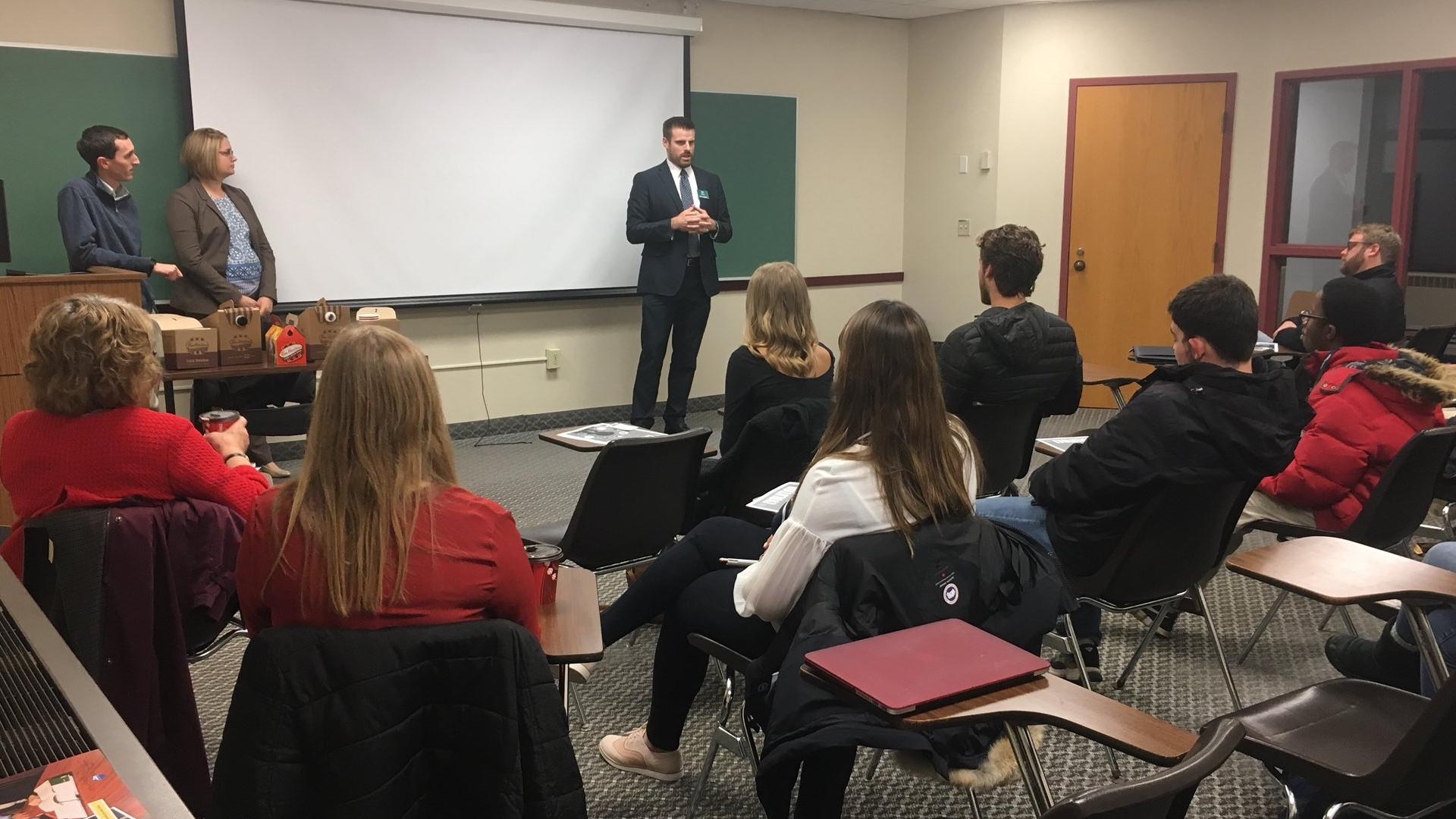 Person in suit giving a classroom presentation.