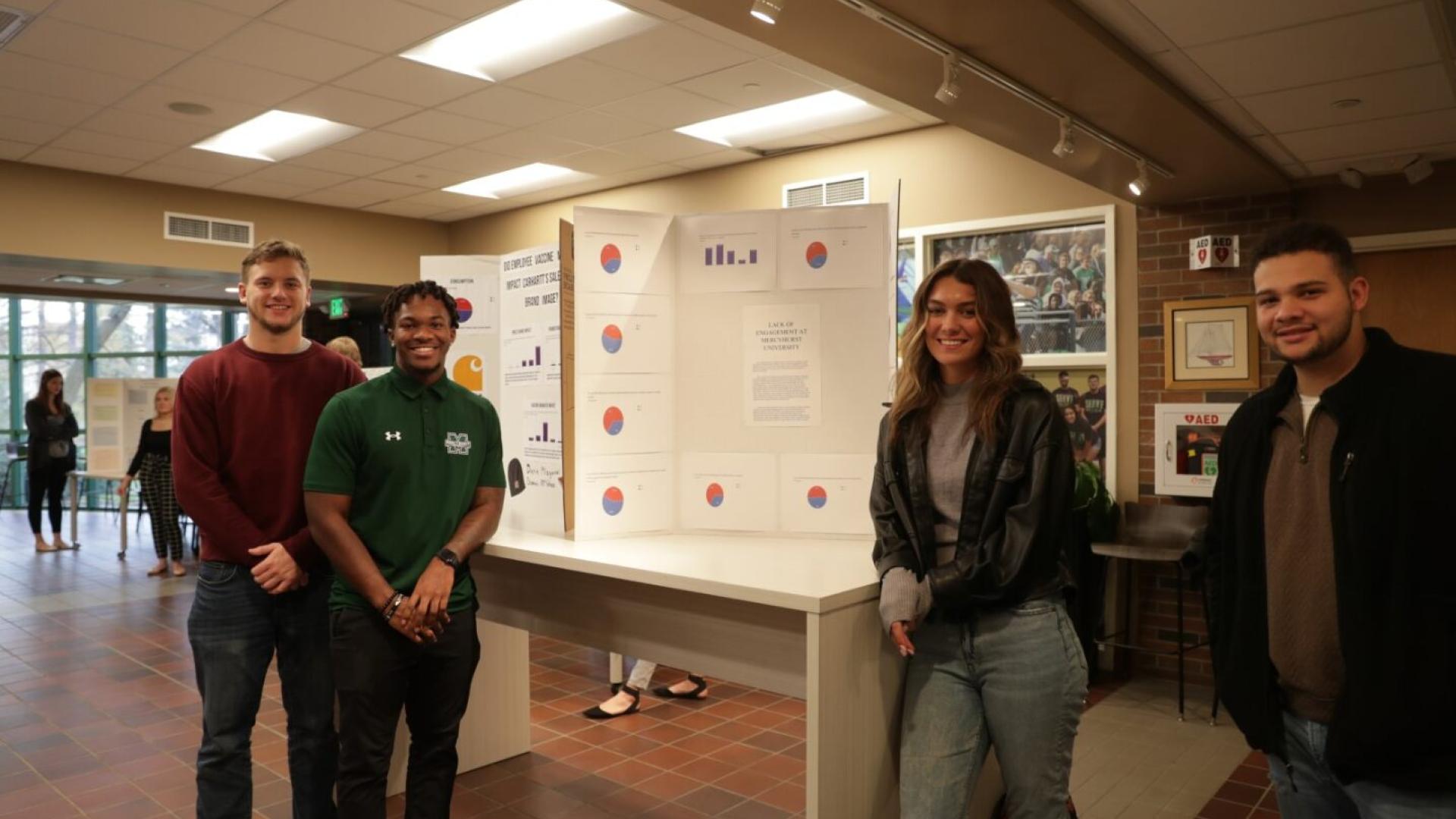 Marketing students posing in front of group project