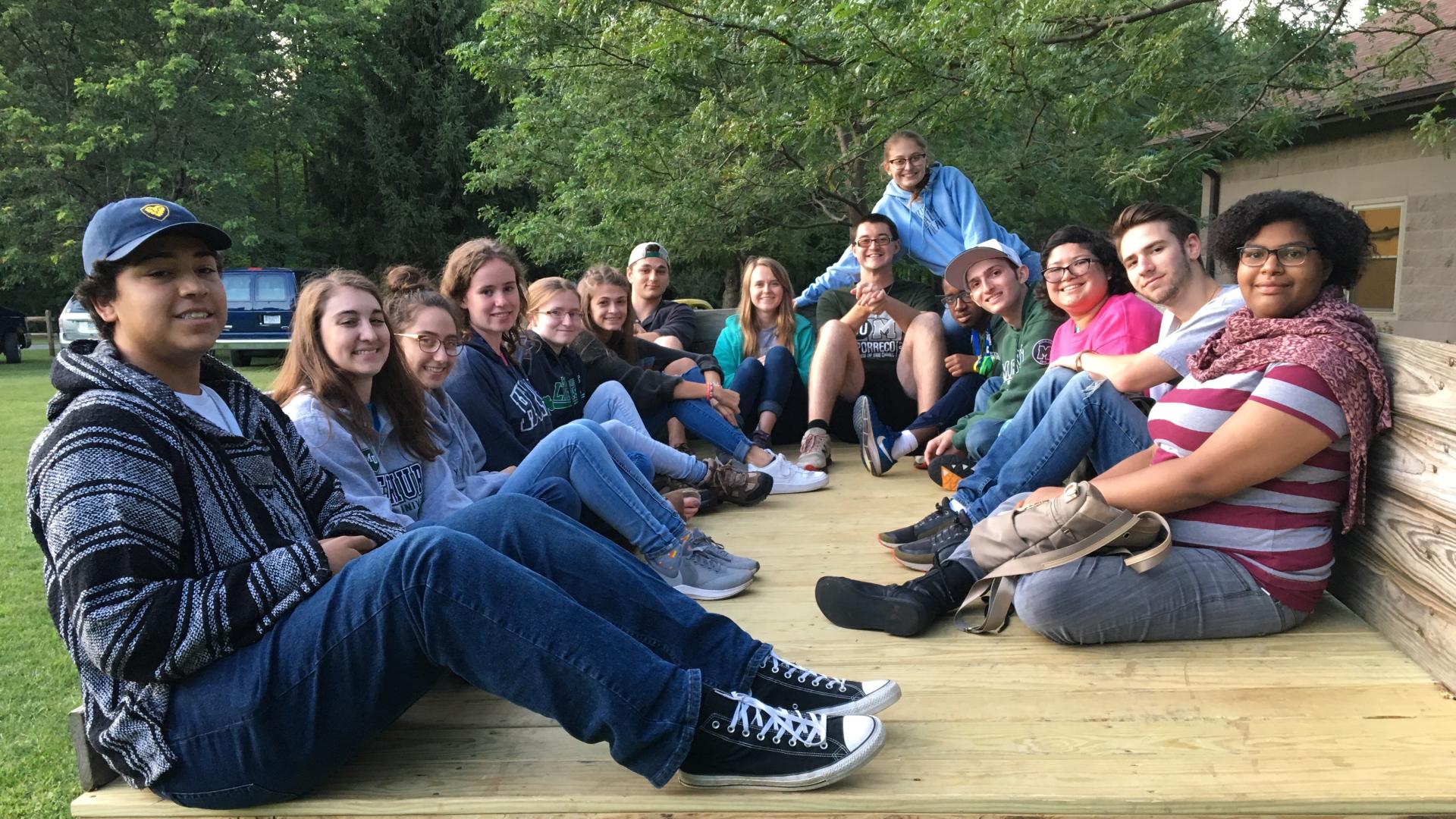 a group of students sit in the back of a tractor