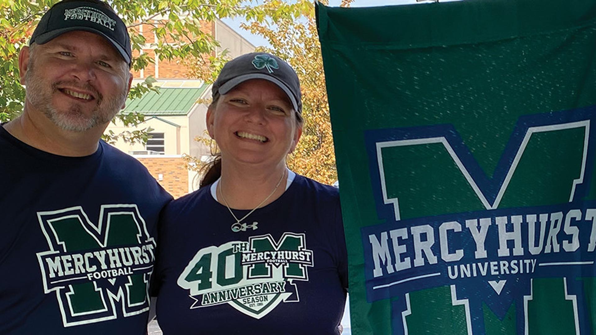 Student and parent pose with school flag