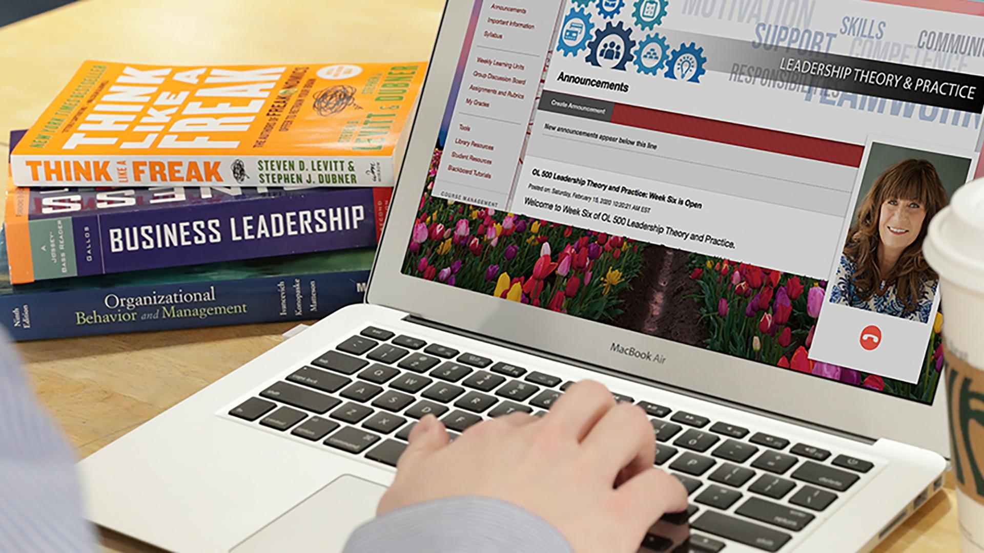 Graduate student on computer with Business books and computer