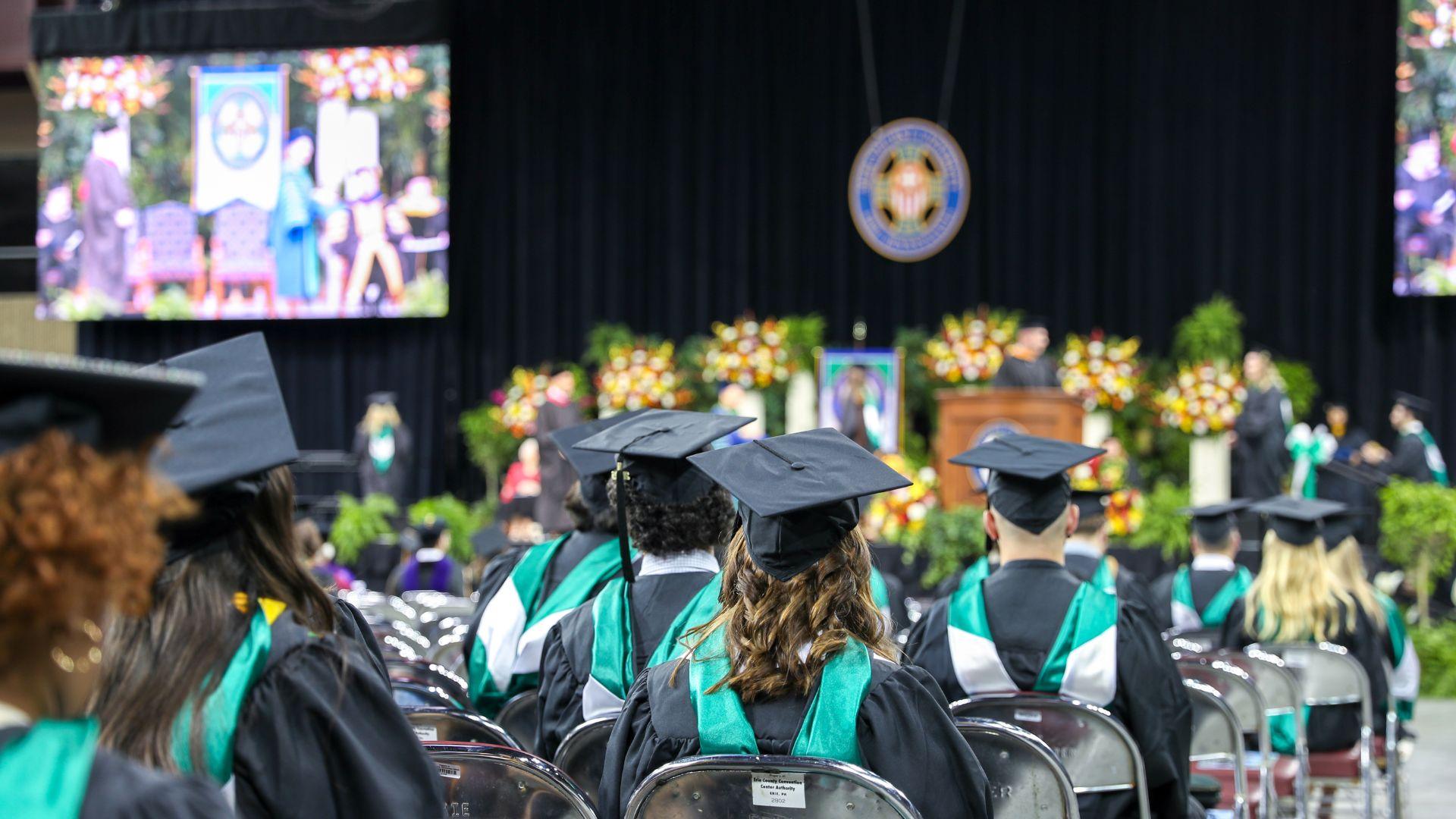 Graduation 2026 graduates in front of stage at Erie Insurance Arena