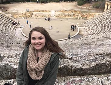 Student poses in ancient civilization site studying abroad