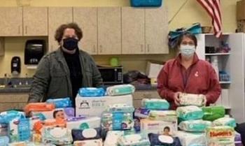 Faculty pose with a large table of donations