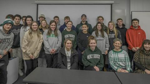 Students posing for a class photo in a classroom setting