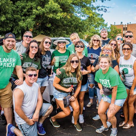 Alumni dressed in spiritwear pose in group photo at Mercyhurst Homecoming.