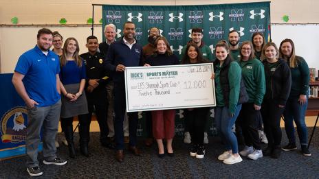 Group photo of Mercyhurst University's new intramural partners Erire Public Schools holding a check for $12,000 Sports Matter grant, provided by Dick's Sporting Goods Foundation