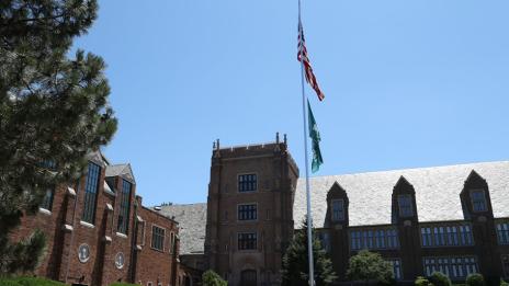 Campus shot of Old Main and American and Mercyhurst flag