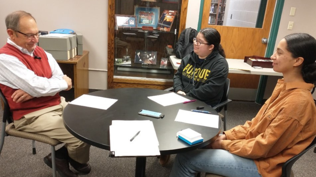 two female students interview a professor