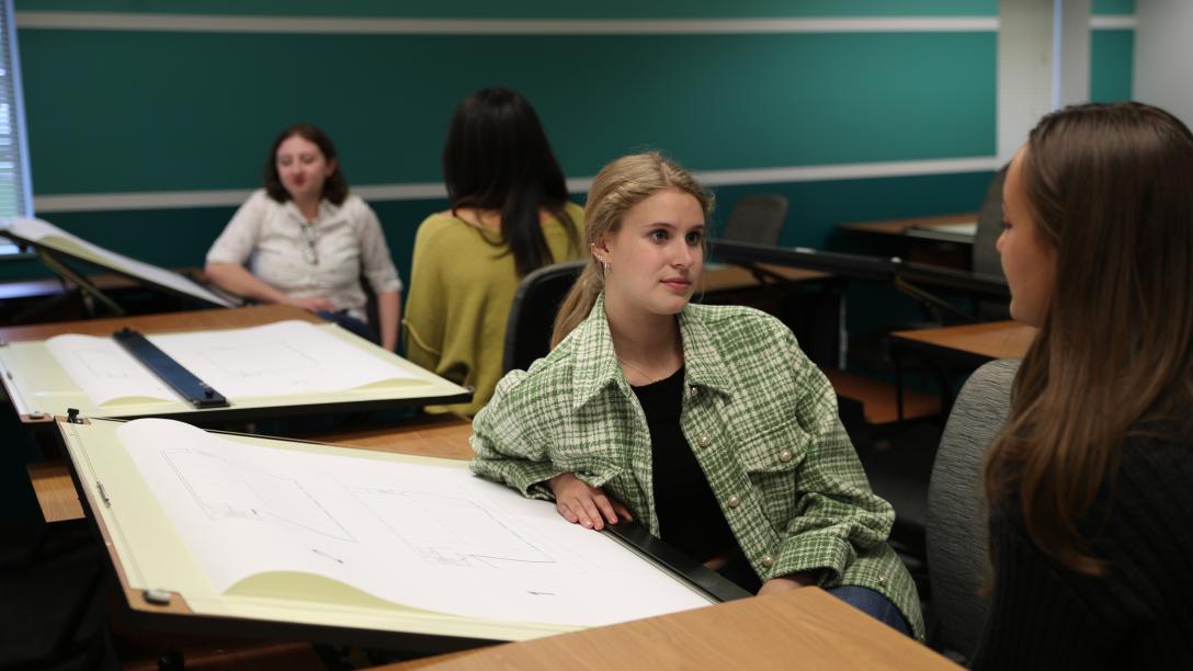 two female students discuss interior design work