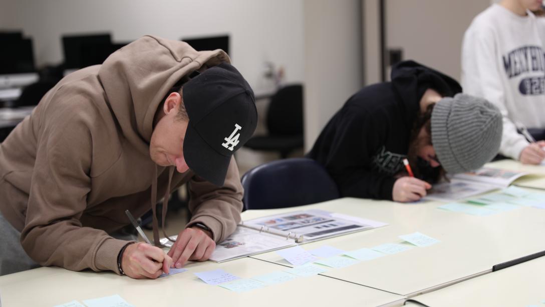 graphic design students sketch on a table