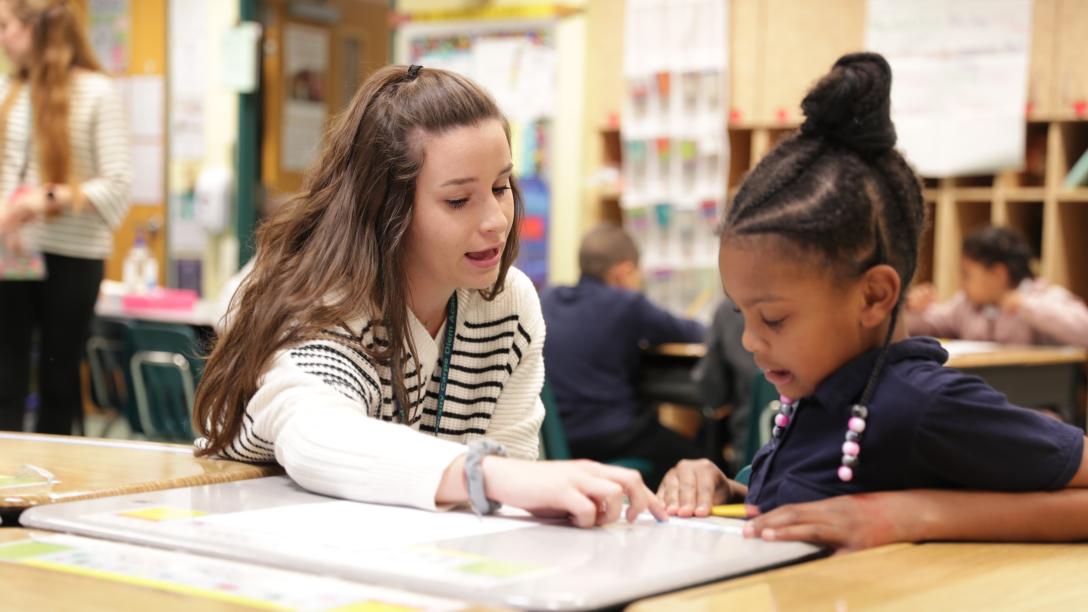 a female student teacher instructs a student