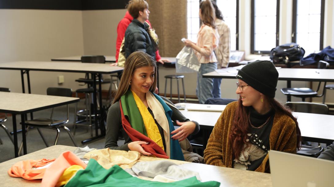 two female fashion students try on colored scarves