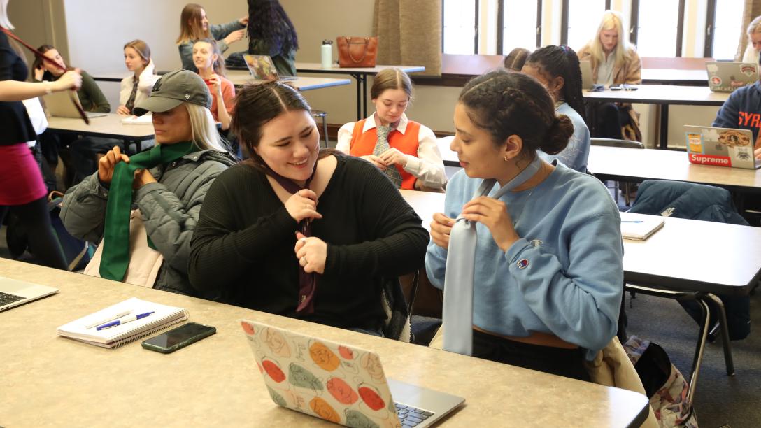 fashion merchandising students practice tying ties