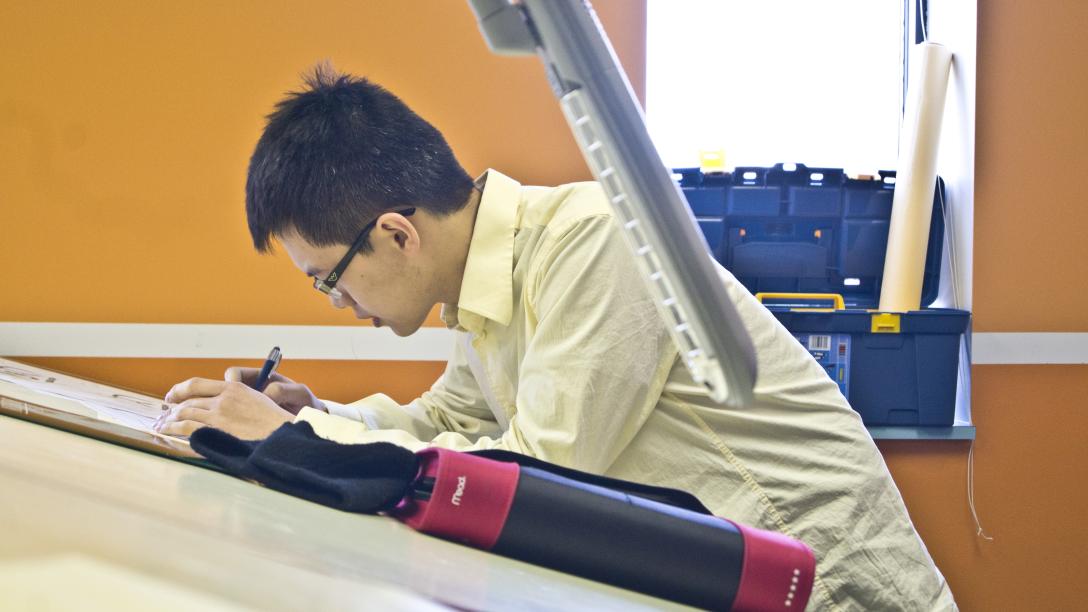 a male student works at an interior architecture desk