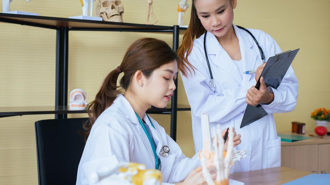 Two female medical students look over paperwork