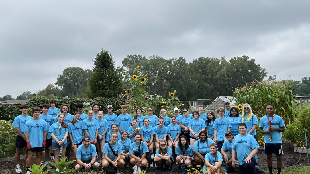 a large group of students poses while doing service