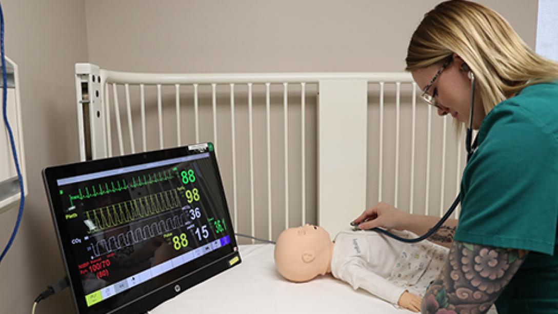 nursing student examines mannequin