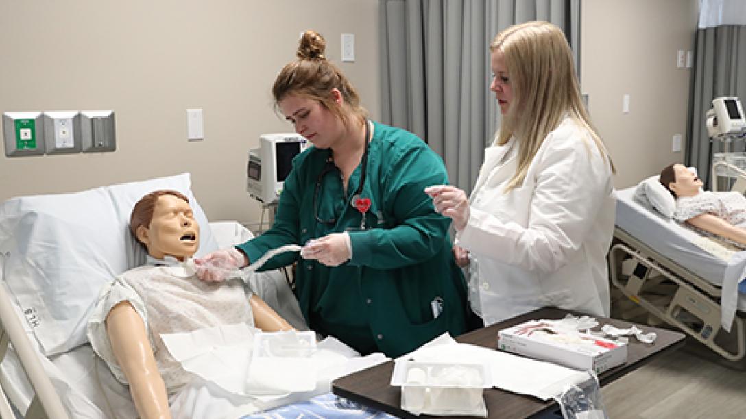 Professor and student working with mannequin