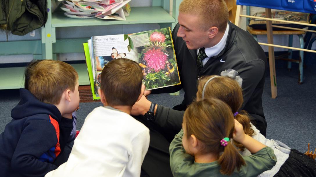 Teacher reading to several elementary students