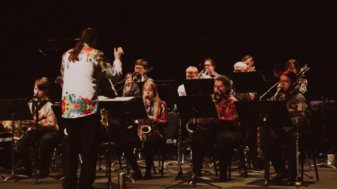 person conducting a group of musicians