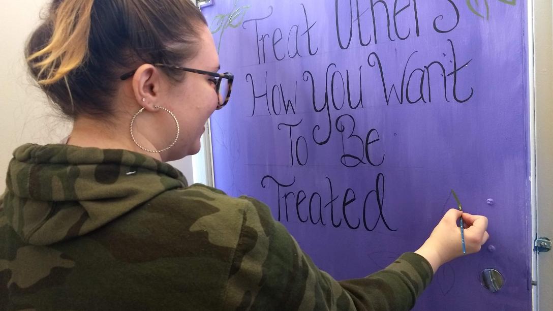 female student working on campus signage