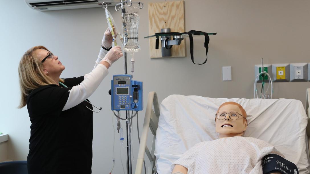 Nursing student adjusting IV pole
