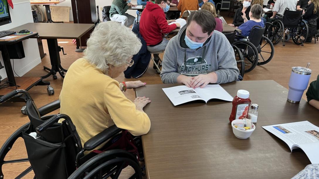 Student and Elmwood Garden Resident Reading