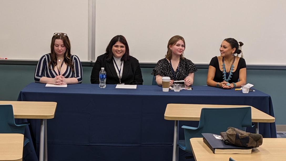 students sit on a panel discussion