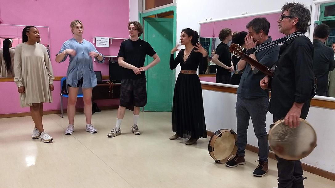 Music students standing having a discussion, holding instruments