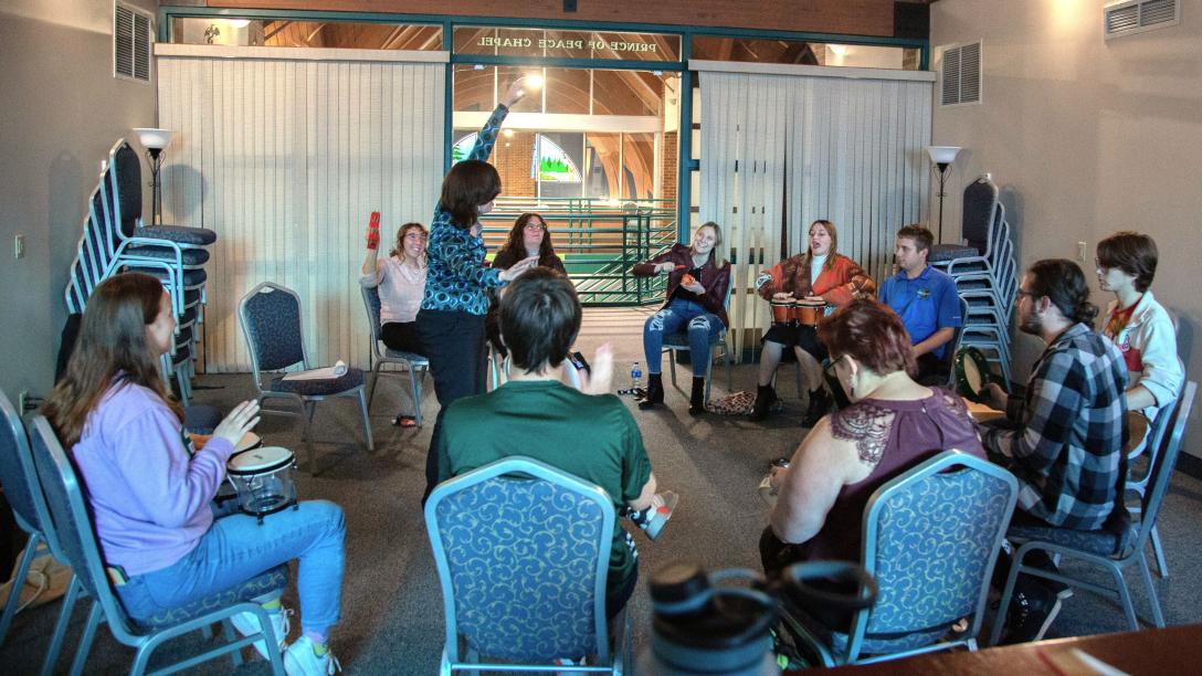 Music Therapy students playing instruments sitting in a circle in a classroom setting