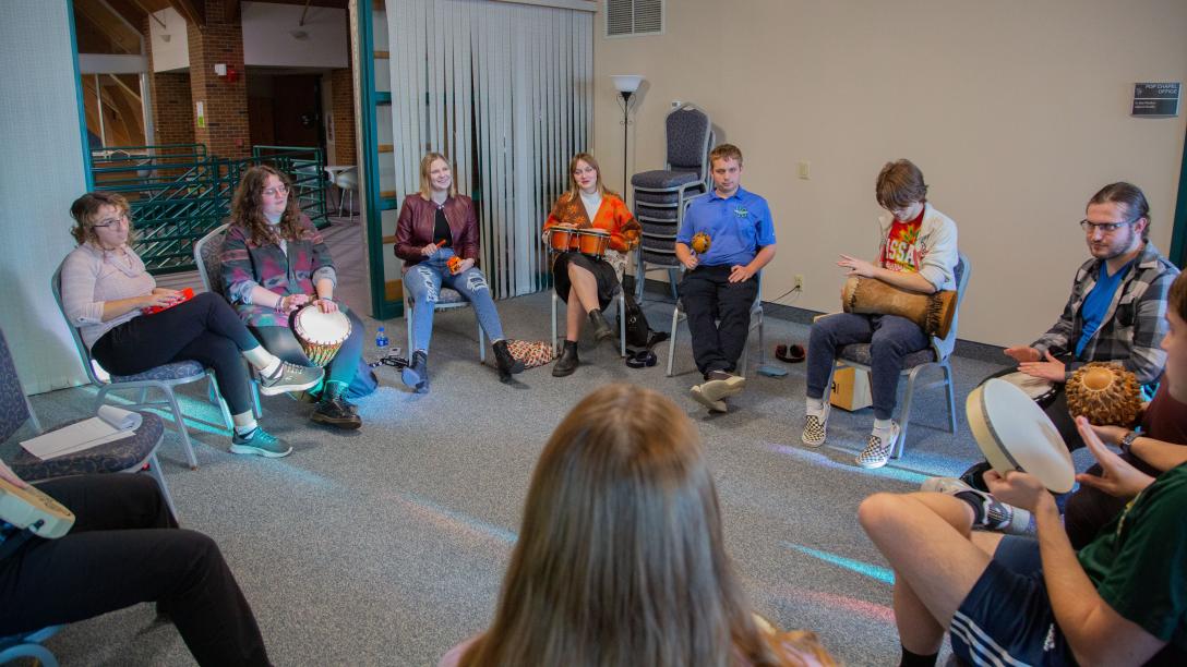 Music Therapy students playing instruments sitting in a circle in a classroom setting
