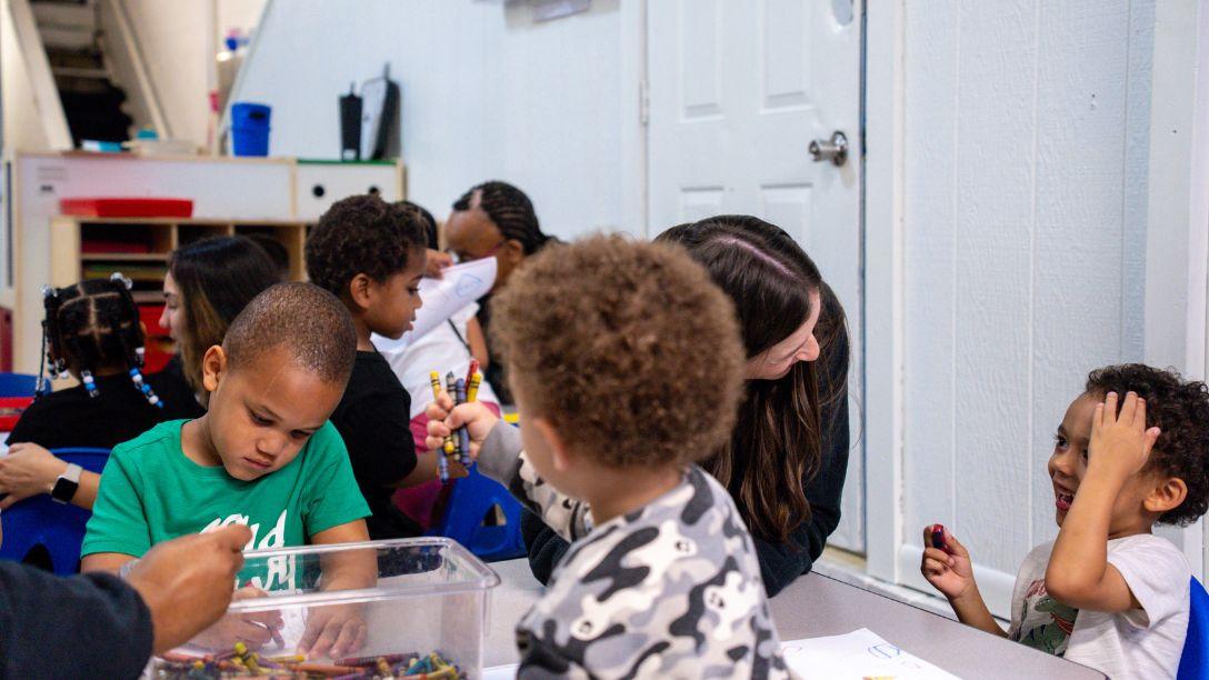 Student and child coloring and talking