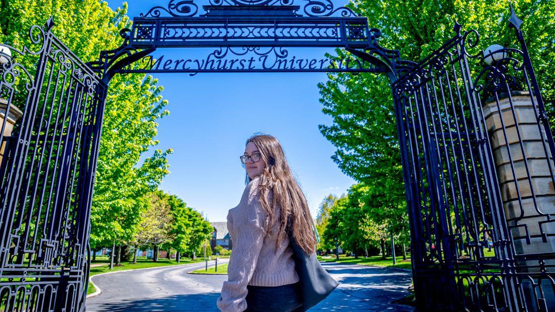 Graduation 2026 one female graduate in front of the gates