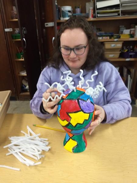 Female student working on mixed media piece of art