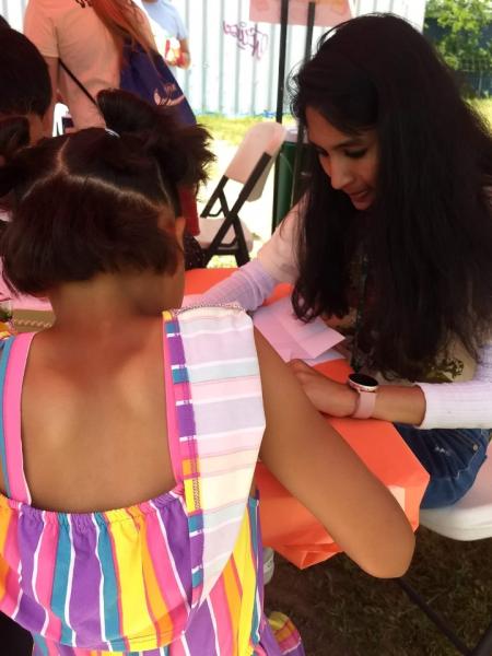 female student working together on art with younger girl 