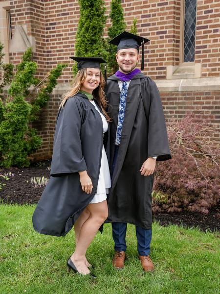 Male and female graduates outside chapel